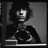 Arto/Self Portrait
Arto Saari
8.5”x11” Hahnemule Matte/Photo Rag 
195/200
$95

Self portrait shortly after acquiring my first
medium format camera.  I got obsessed in
making pictures while traveling through
skateboarding.  Sometimes I got made fun of cause I didn’t even know how to use the
equipment properly.  Skateboarding teaches you certain kinda tenacity and I just figured try to learn it hands on on the streets than get too caught up in the technical side of things.